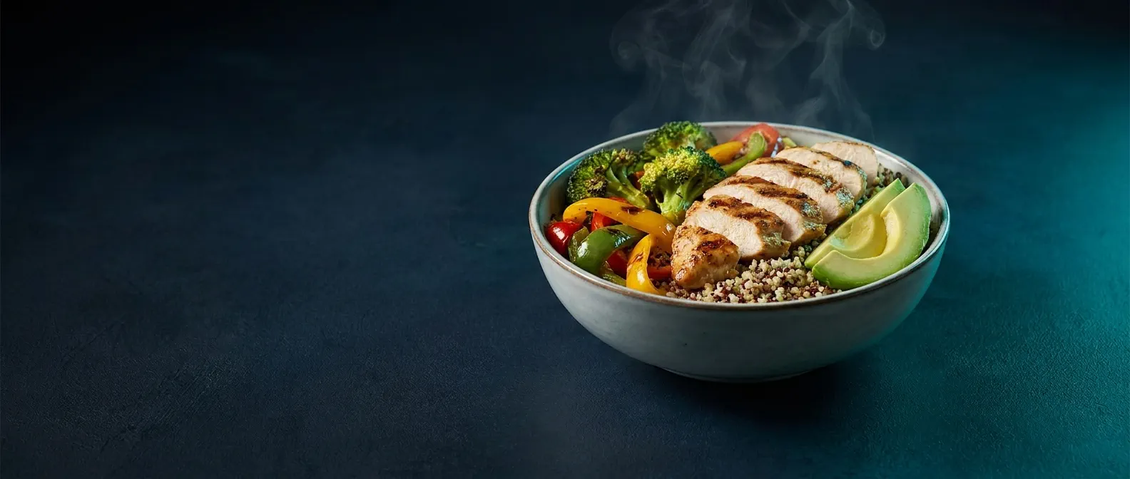 A high-protein bowl on a dark navy surface, lit with teal light